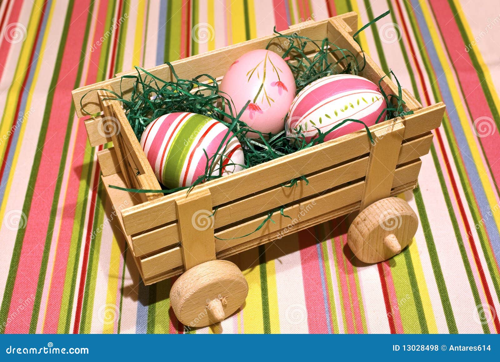 Eggs Anlieferung. Ostereier auf einem hölzernen Spielzeug Chariot über farbigem Hintergrund