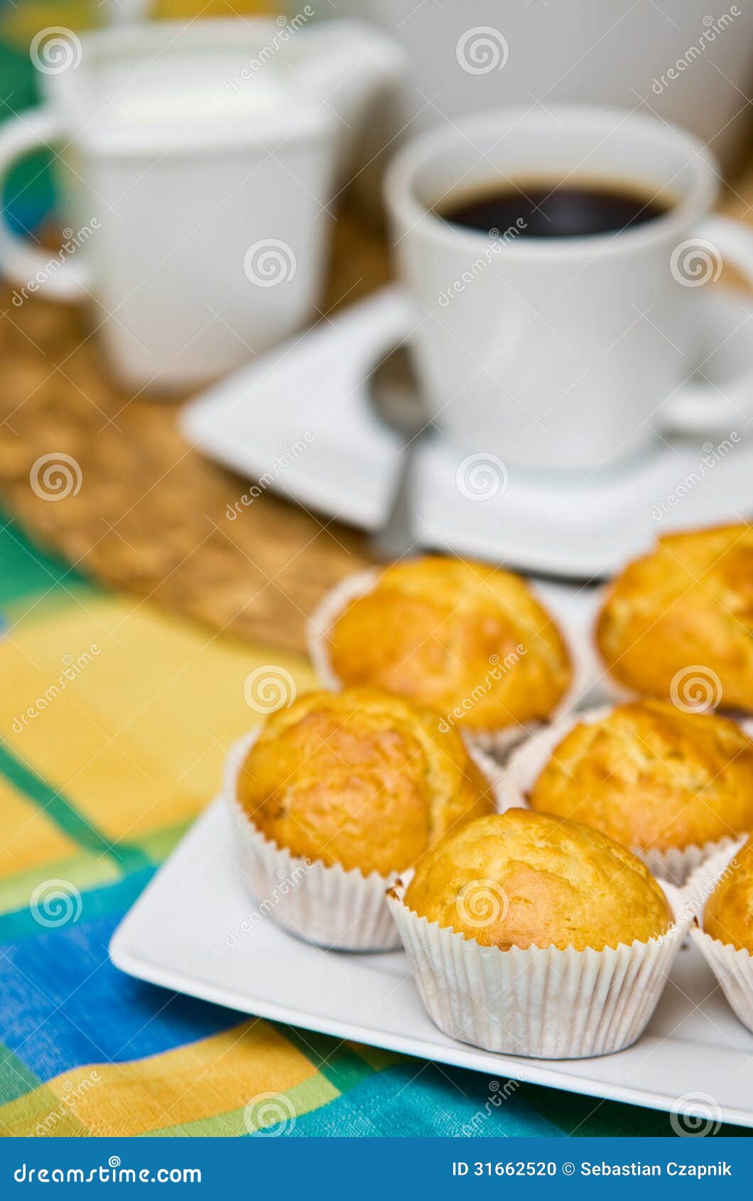 Eigengemaakte muffins. Stillevenbeeld van smakelijke eigengemaakte die muffins op kleurrijk tafelkleed worden geschikt.