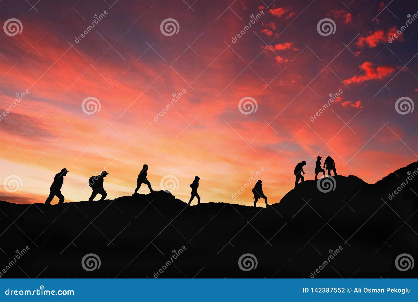 eight friends walk on mountain path in sunset