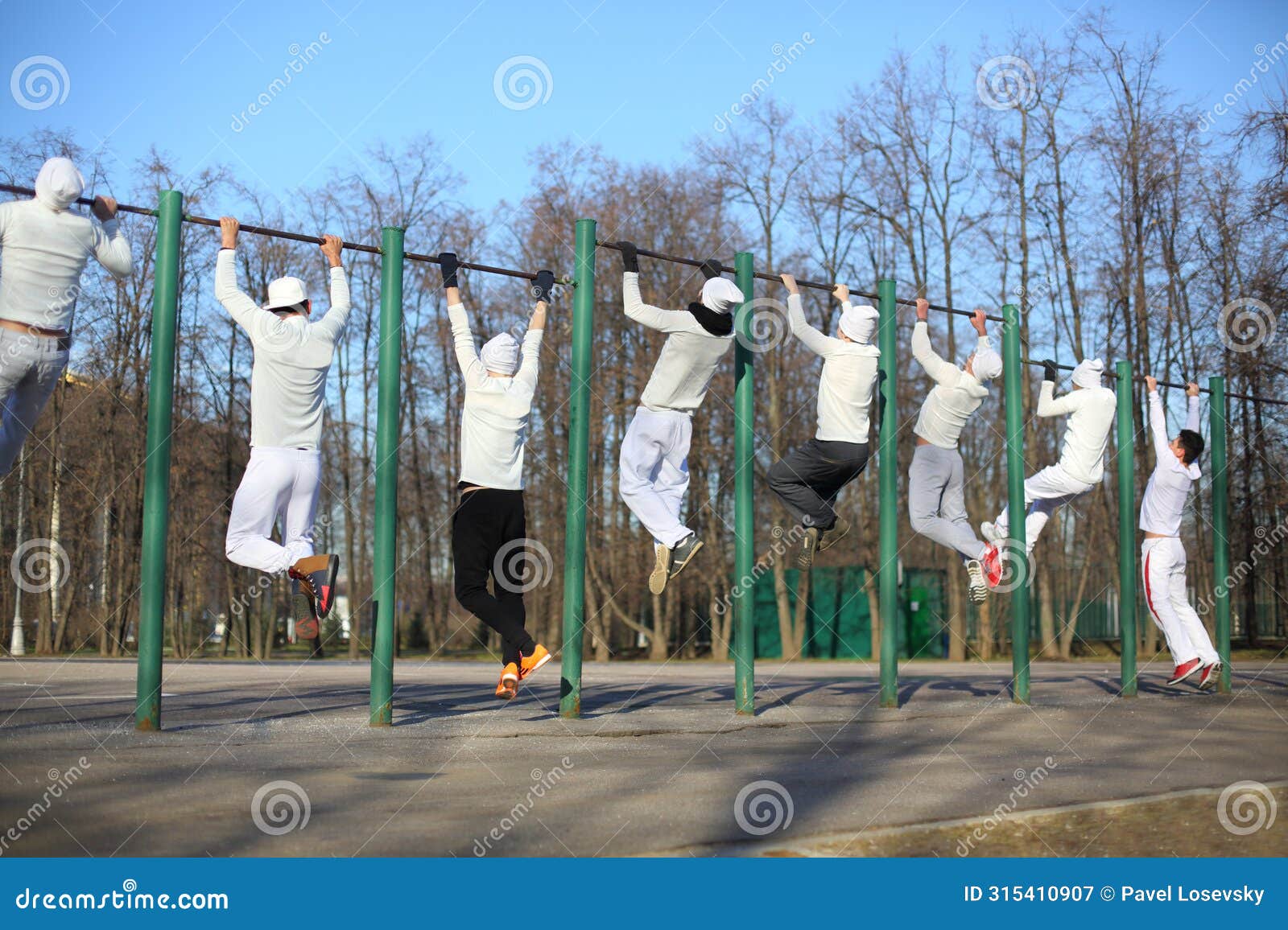 eight young men training on the horizontal bar on