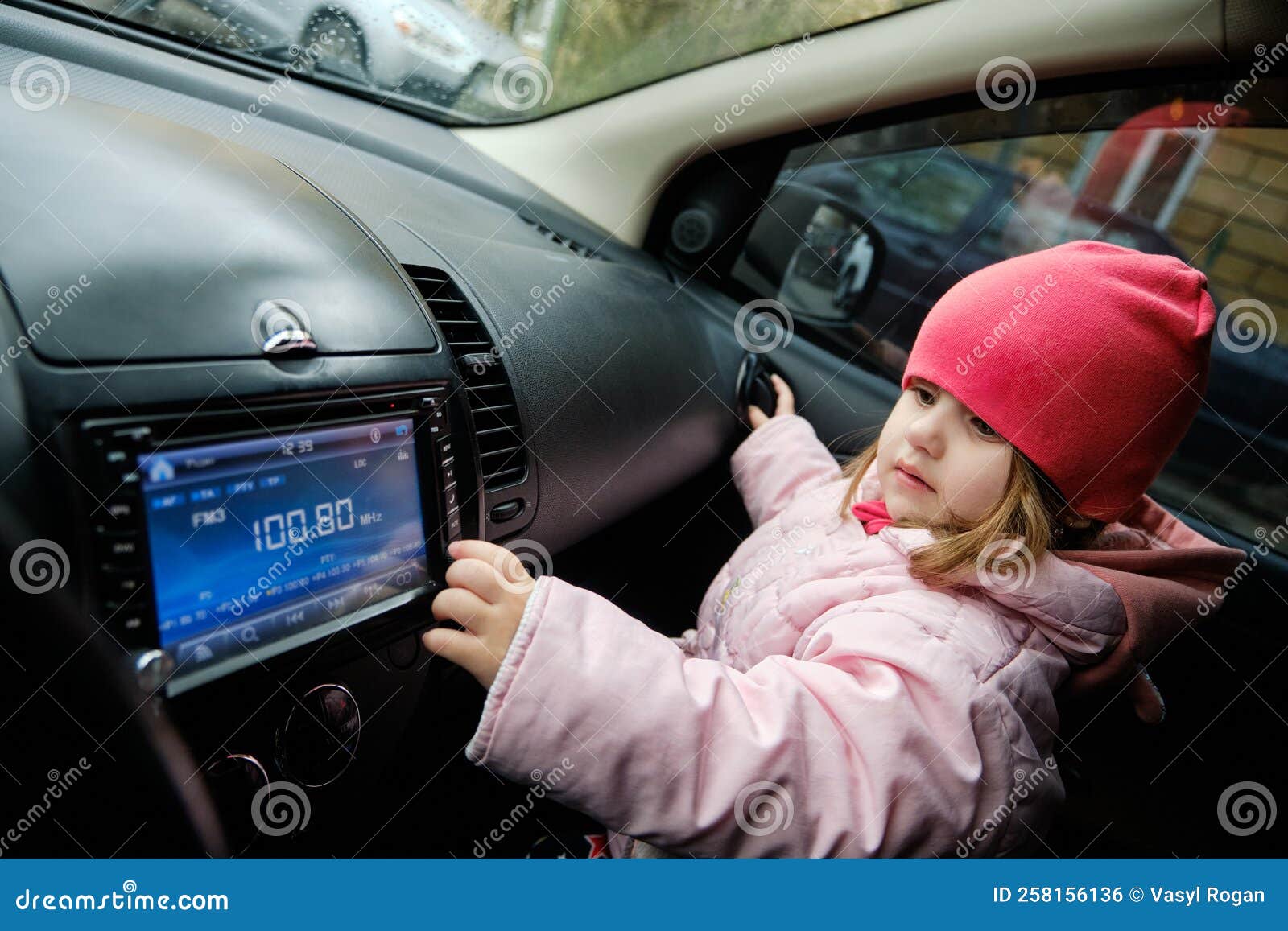 Ein Kleines Mädchen, Das Den Radiosender Wechselt, Während Es Musik Im Auto  Hört. Radio Im Auto Hören Stockfoto - Bild von auto, multimedia: 258156136