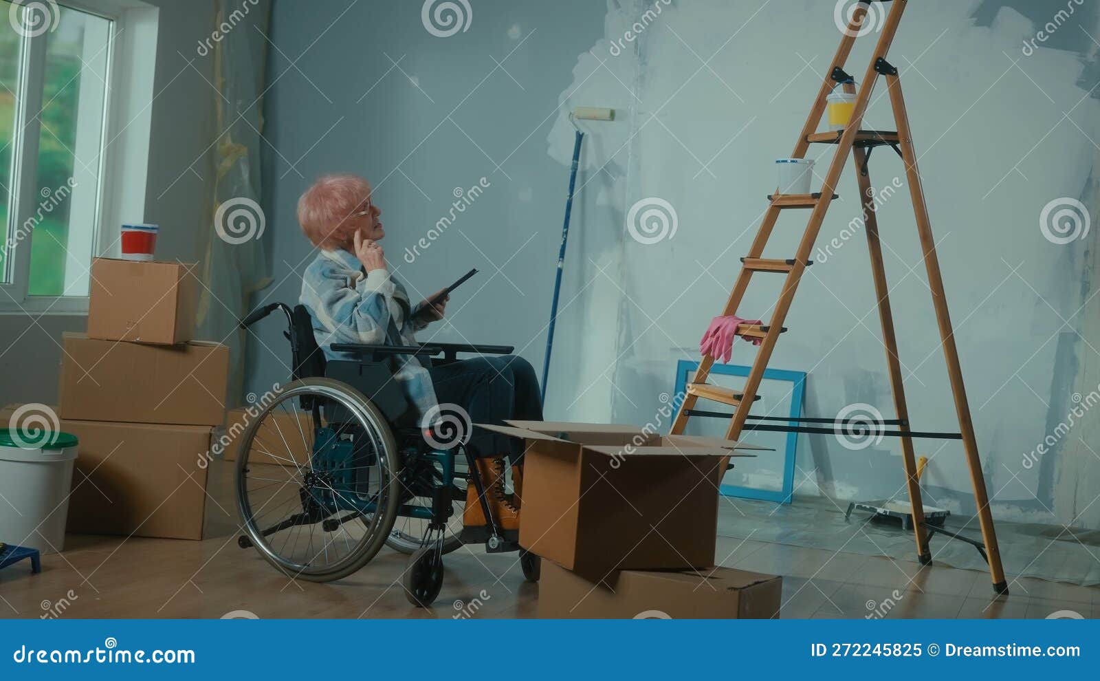 Eine ältere Behinderte Frau in Einem Rollstuhl Plant Eine Renovierung Mit  Einem Digitalen Tablett. Zimmer Mit Fensterladenkarton Stockbild - Bild von  handikap, auslegung: 272245825