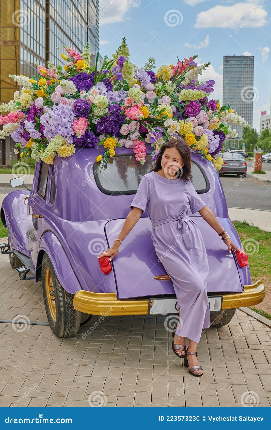 Eine Frau Steht Neben Dem Auto Mit Blumen Stockfoto - Bild von