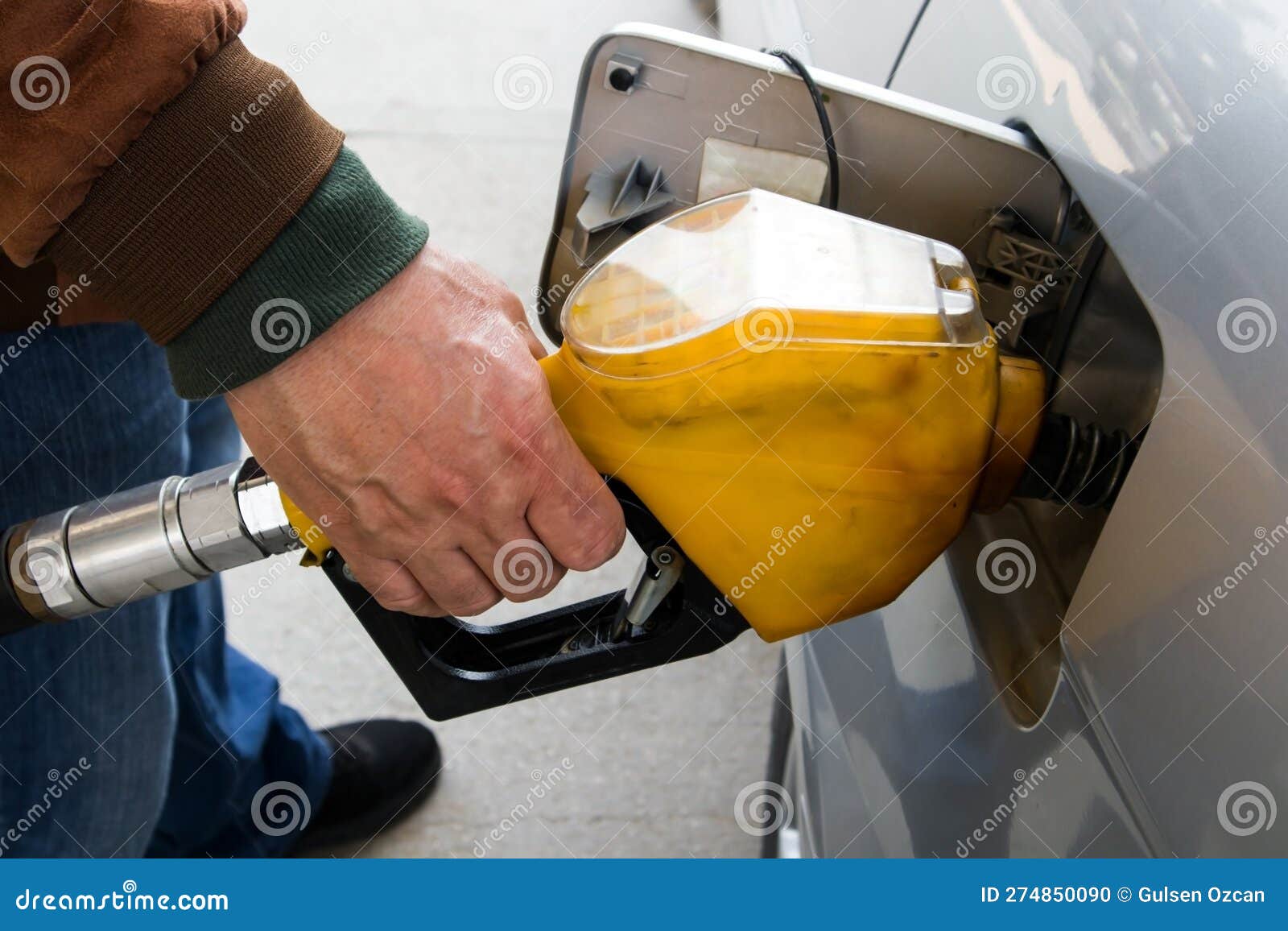 Nahaufnahme einer Hand, die mit einer Benzinpumpe Gas in das Auto