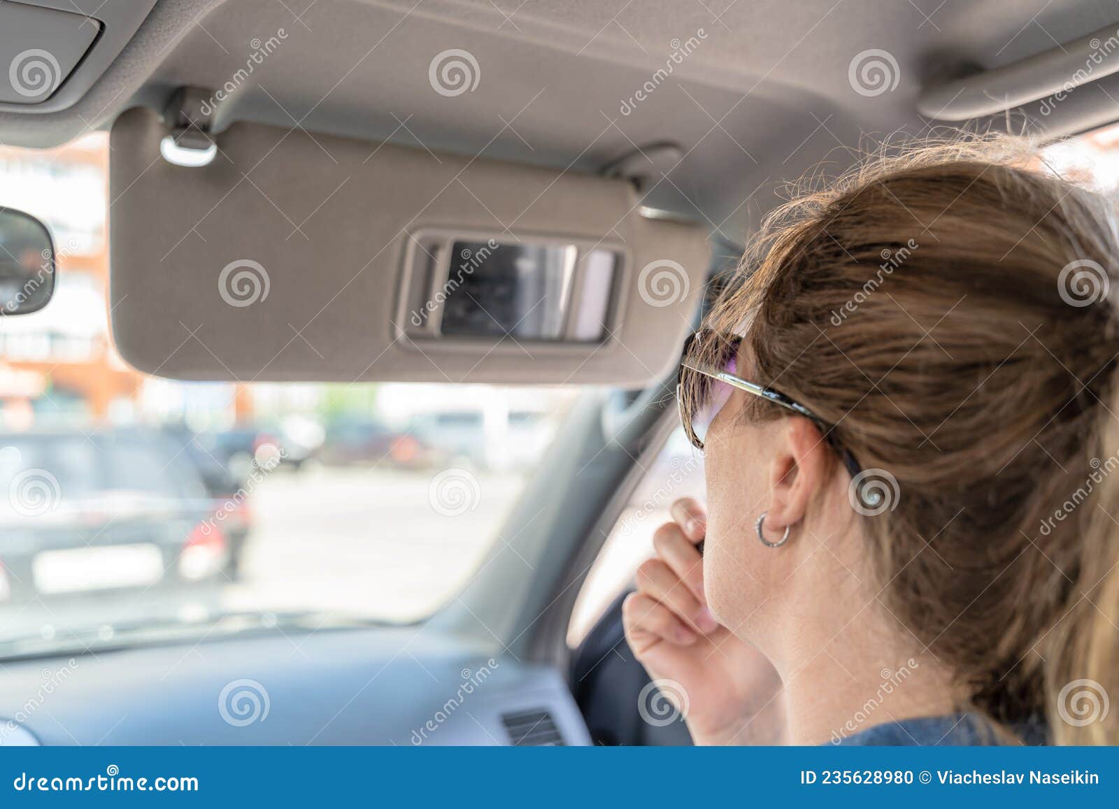 Eine Junge Mittelaltrige Frau Schminkt Sich Mit Lippenstift Im Auto,  Während Sie in Einen Kleinen Spiegel in Einem Visier Schaut Stockfoto -  Bild von lippenstift, spiegel: 235628980