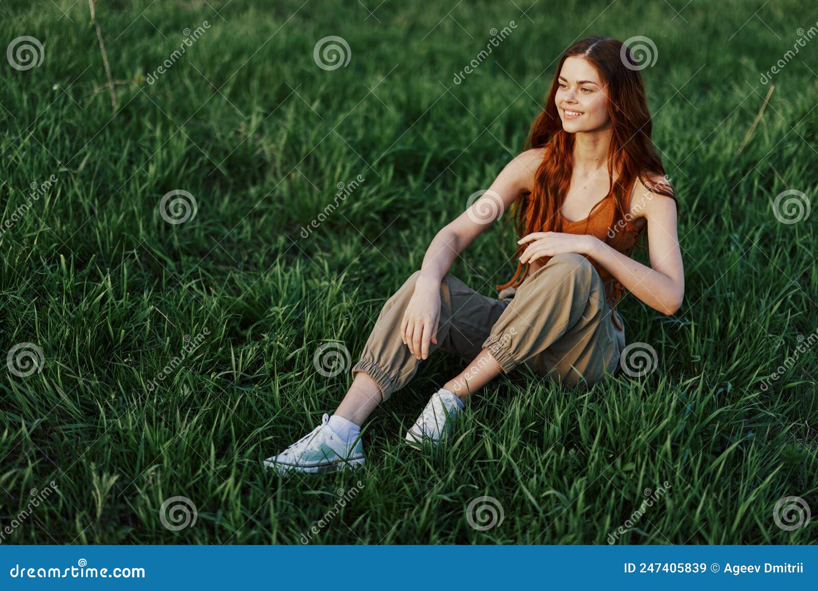 Eine Schöne, Magere Frau Sitzt in Lockerer Kleidung Auf Dem Gras Und  Entspannt Sich Beim Sonnenuntergang Vom Sport. Stockbild - Bild von park,  gerät: 247405839