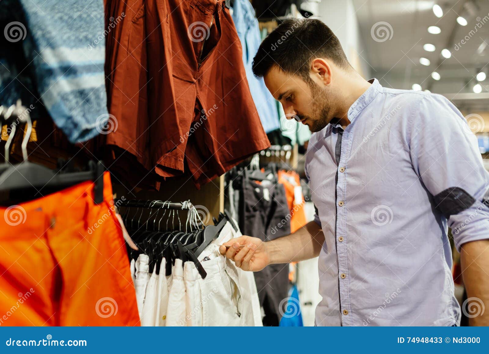 Einkaufen des gutaussehenden Mannes für Kleidung. Gut aussehender Mann, der neue Kleidung kauft