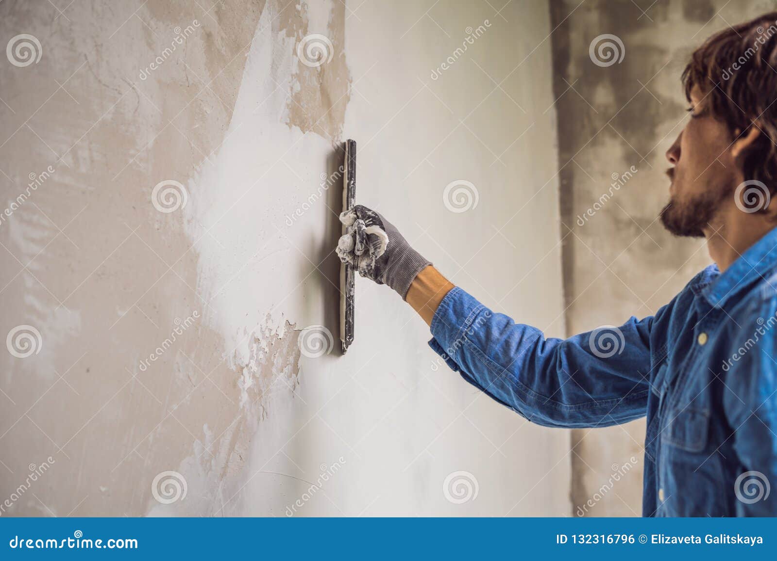 El Amo Está Aplicando La Masilla Blanca En Una Pared Y La Está Manchando  Por El Cuchillo De Masilla En Un Cuarto De Renovar La Ca Foto de archivo -  Imagen de