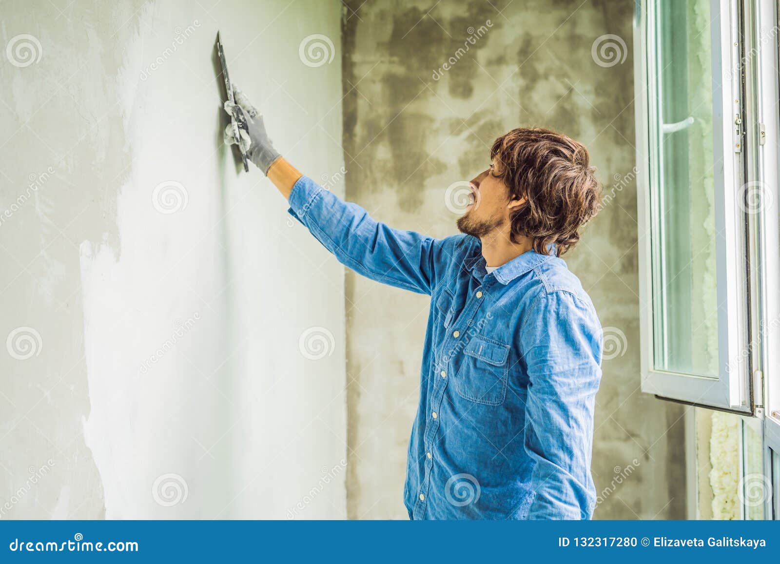 El Amo Está Aplicando La Masilla Blanca En Una Pared Y La Está Manchando  Por El Cuchillo De Masilla En Un Cuarto De Renovar La Ca Foto de archivo -  Imagen de