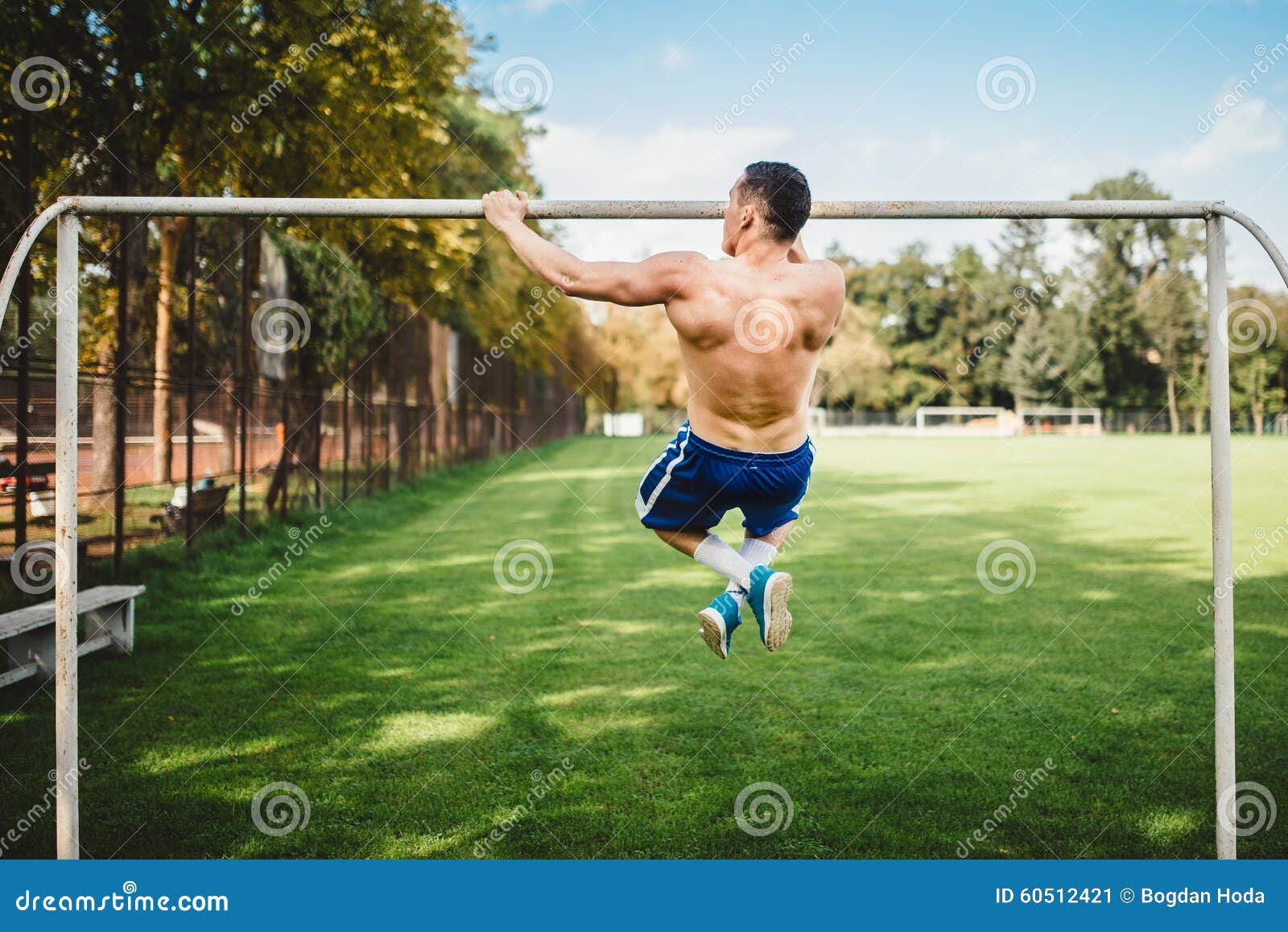 El atleta de sexo masculino que hace tirón sube, barbilla sube en el parque Hombre atheltic de la aptitud que se resuelve y que entrena en el parque Concepto apto de la cruz