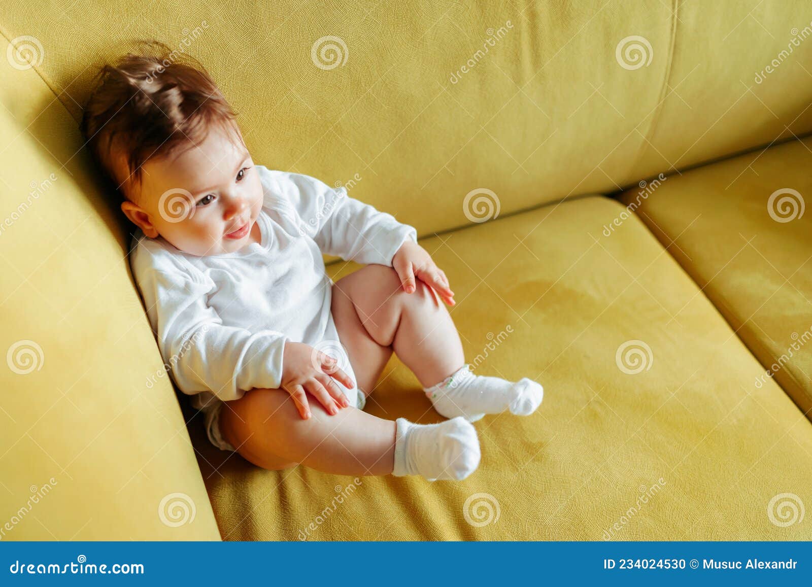 Bebé sentado en un sillón imagen de archivo. Imagen de feliz