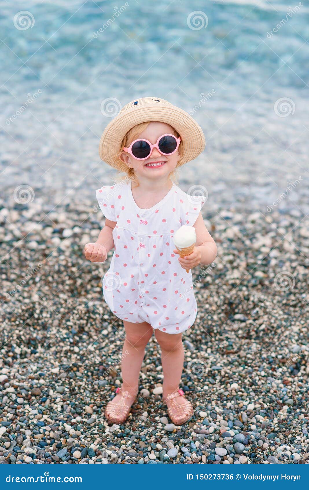 El Bebé Feliz Vestido En Ropa Del Verano, Sombrero Amarillo Y Soportes Rosados De Gafas De Sol En La Playa Come El Helado Bla Foto de archivo - Imagen de leche,