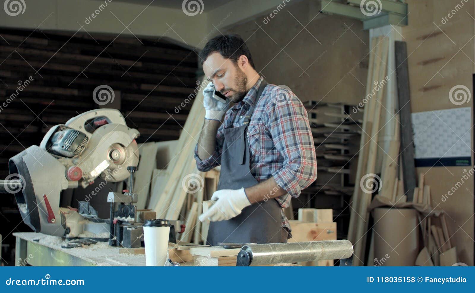 El carpintero que trabaja en su arte en un taller polvoriento y habla el teléfono Tiro profesional en BMCC CRUDO con el alto rango dinámico Usted puede utilizarlo e g en su vídeo comercial, corporativo, negocio, presentación, vídeo de la difusión