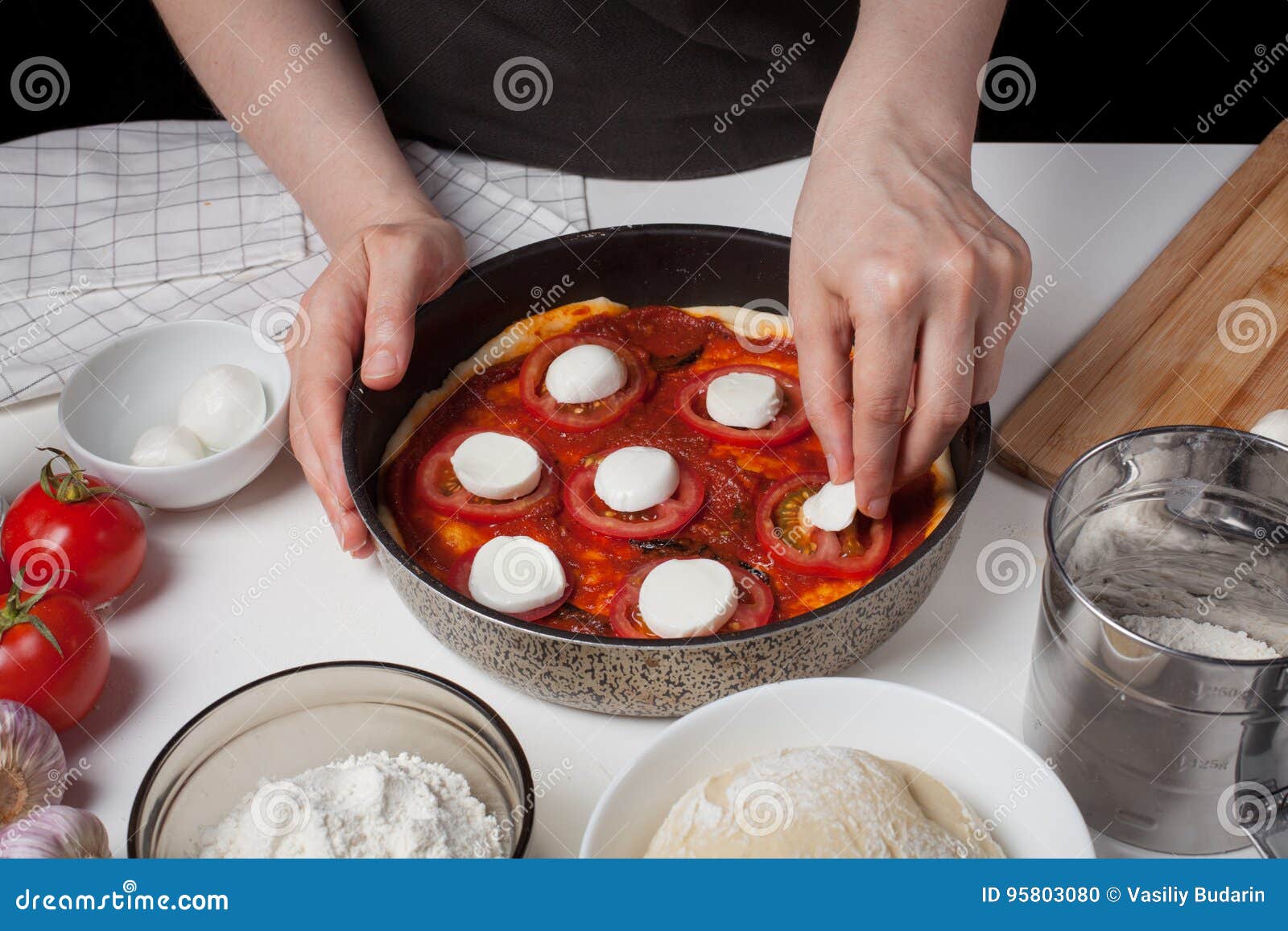 El Cocinero De Sexo Femenino Añade El Queso a La Mozzarella Para Hacer La Pizza Hecha En Casa En La Tabla Blanca Son La Mozzarell Foto de archivo