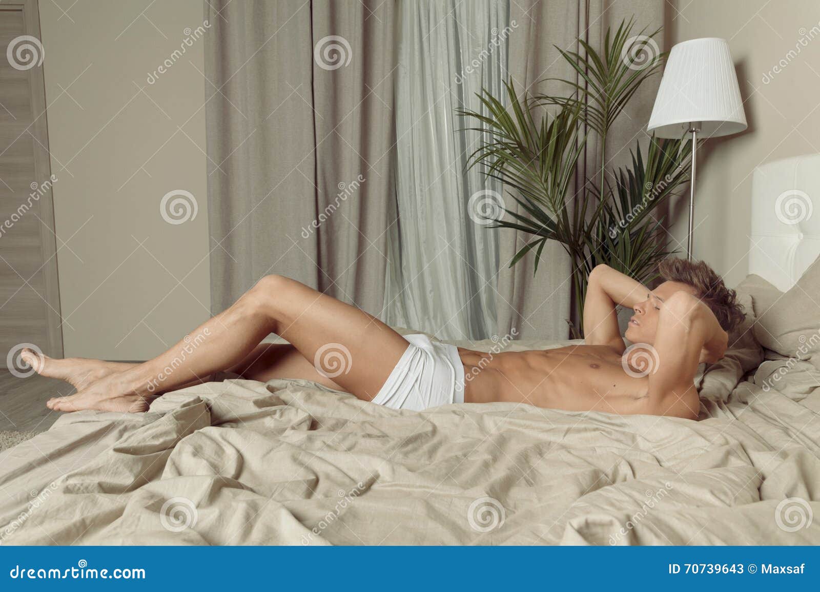El Hombre Apto En Ropa Interior Se Relaja En Cama En Dormitorio Imagen de  archivo - Imagen de hombre, joven: 70739643
