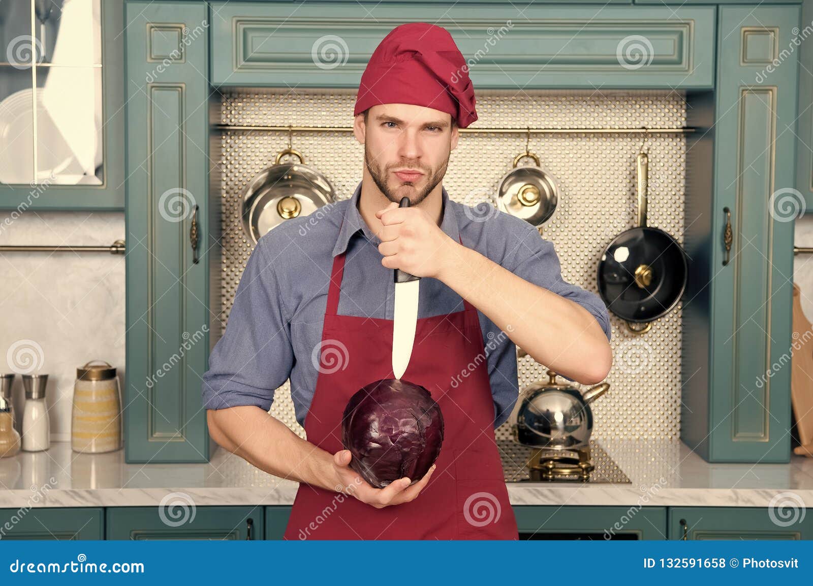 El Hombre En Sombrero Rojo Del Cocinero Cortó La Col Púrpura Con