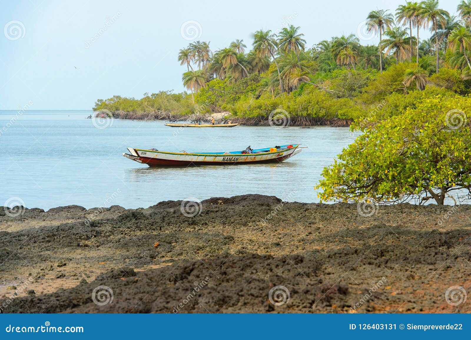 El hombre local no identificado navega en el barco en la costa del tan. SOGA, GUINEA-BISSAU - 5 DE MAYO DE 2017: El hombre local no identificado navega en el barco en la costa de la isla de Soga, parte del archipiélago de Bijagos