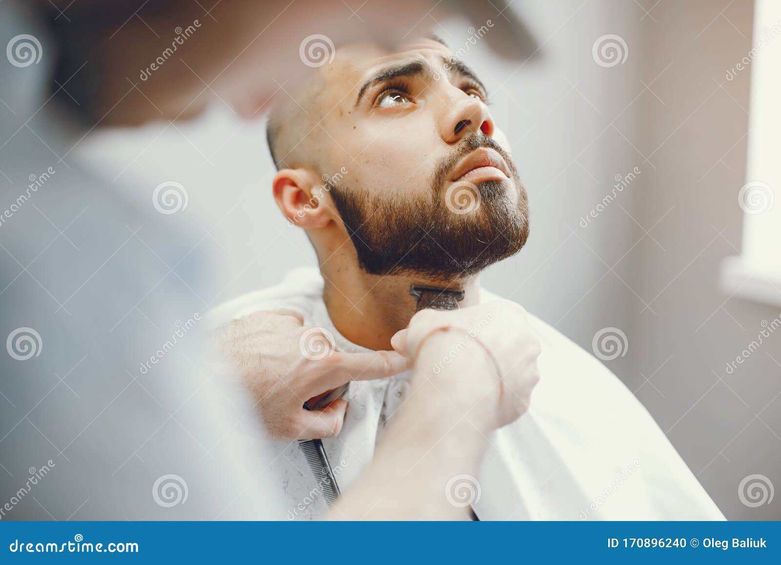 El Hombre Se Corta La Barba En La Barbería Foto de archivo