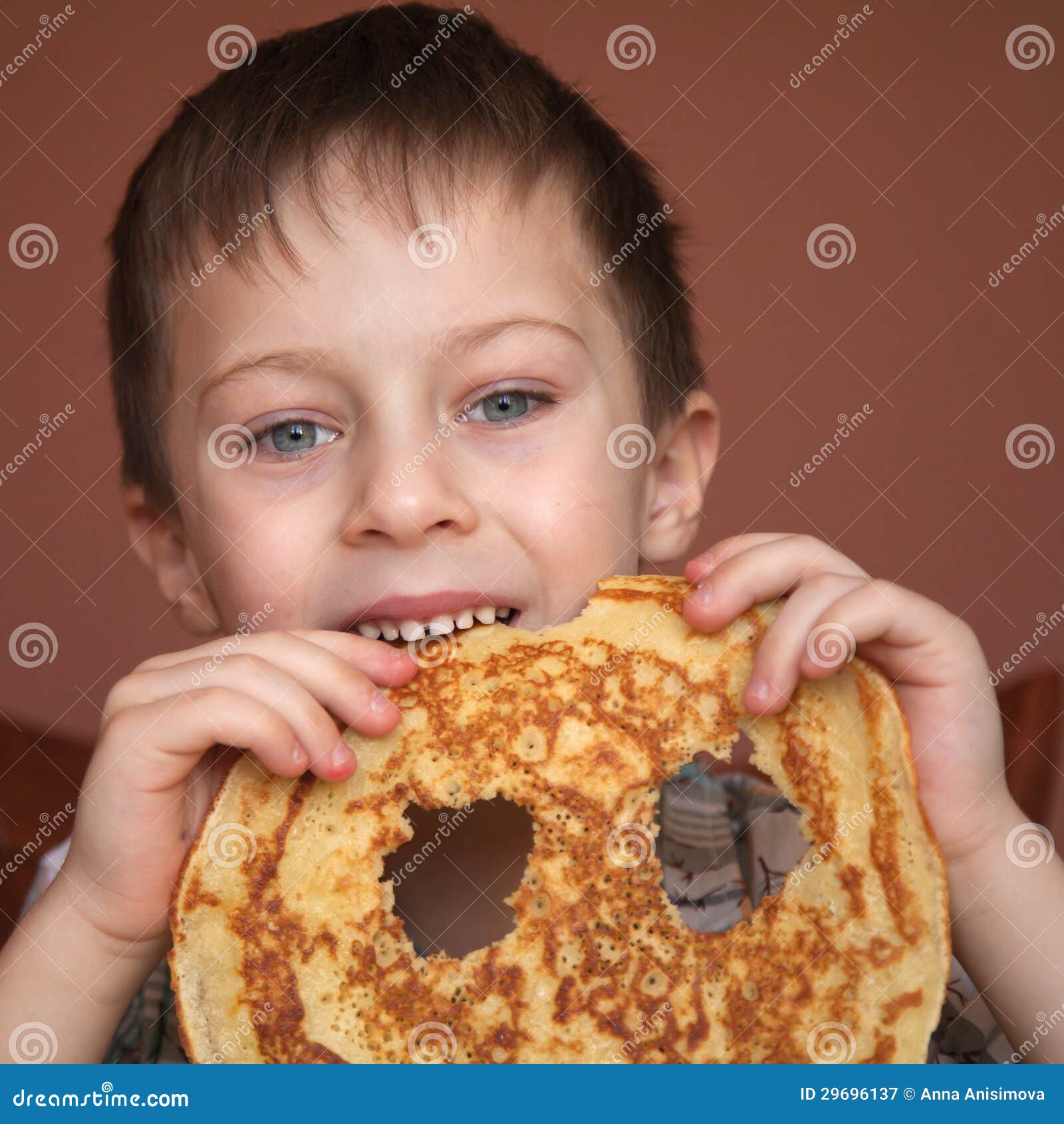 El muchacho lindo está comiendo la crepe. El muchacho de Liitle está comiendo la crepe sabrosa