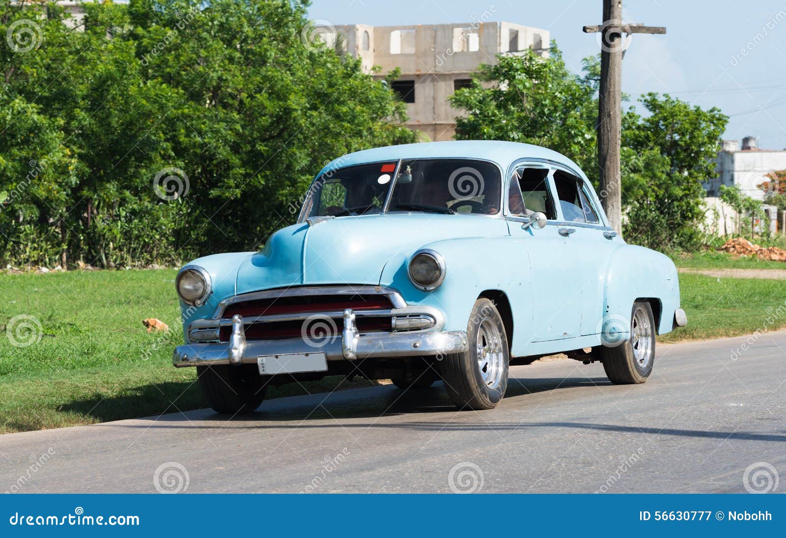 El Oldtimer azul americano de Cuba conduce en el camino. Oldtimer americano de Cuba en el camino