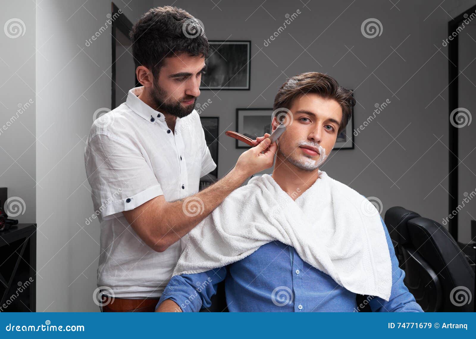 Un barbero recortando la barba de un hombre con maquinillas
