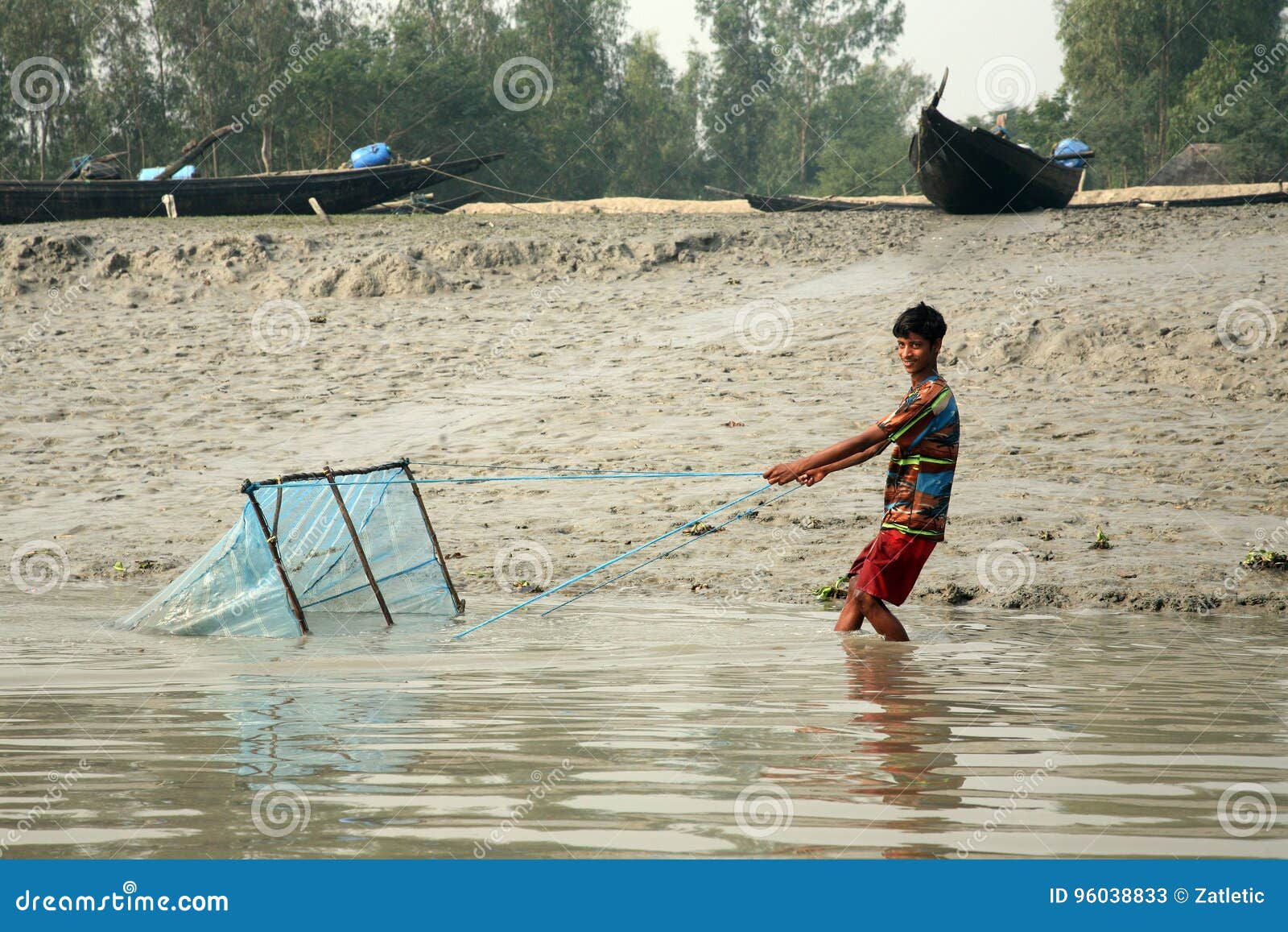 El Pescador Utiliza La Red De Pesca En Una Manera Tradicional Para