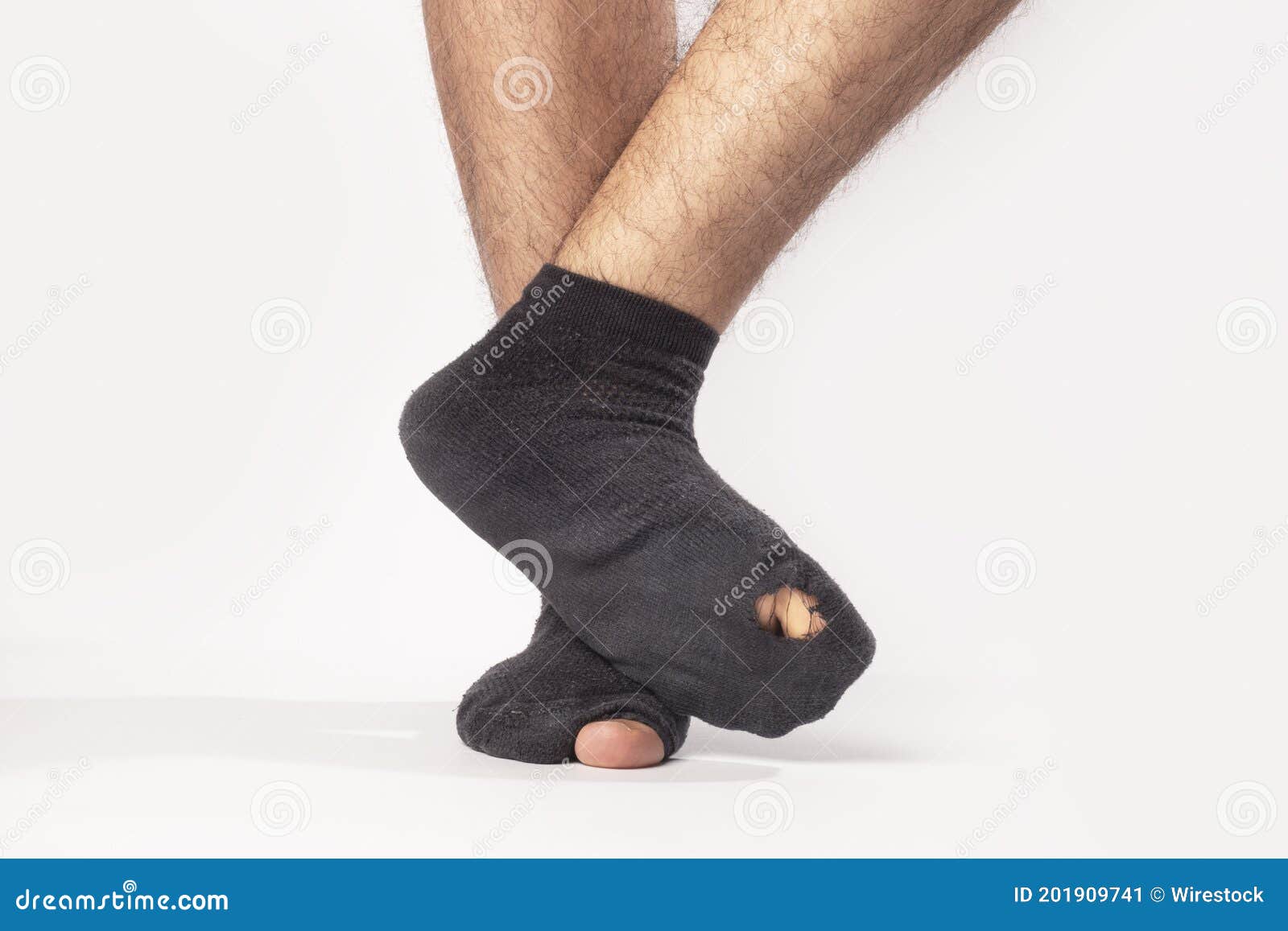 El Primero De Los Pies De Un Hombre Que Lleva Calcetines Negros Con  Agujeros Aislados En Un Fondo Gris Imagen de archivo - Imagen de  desgastado, desgaste: 201909741