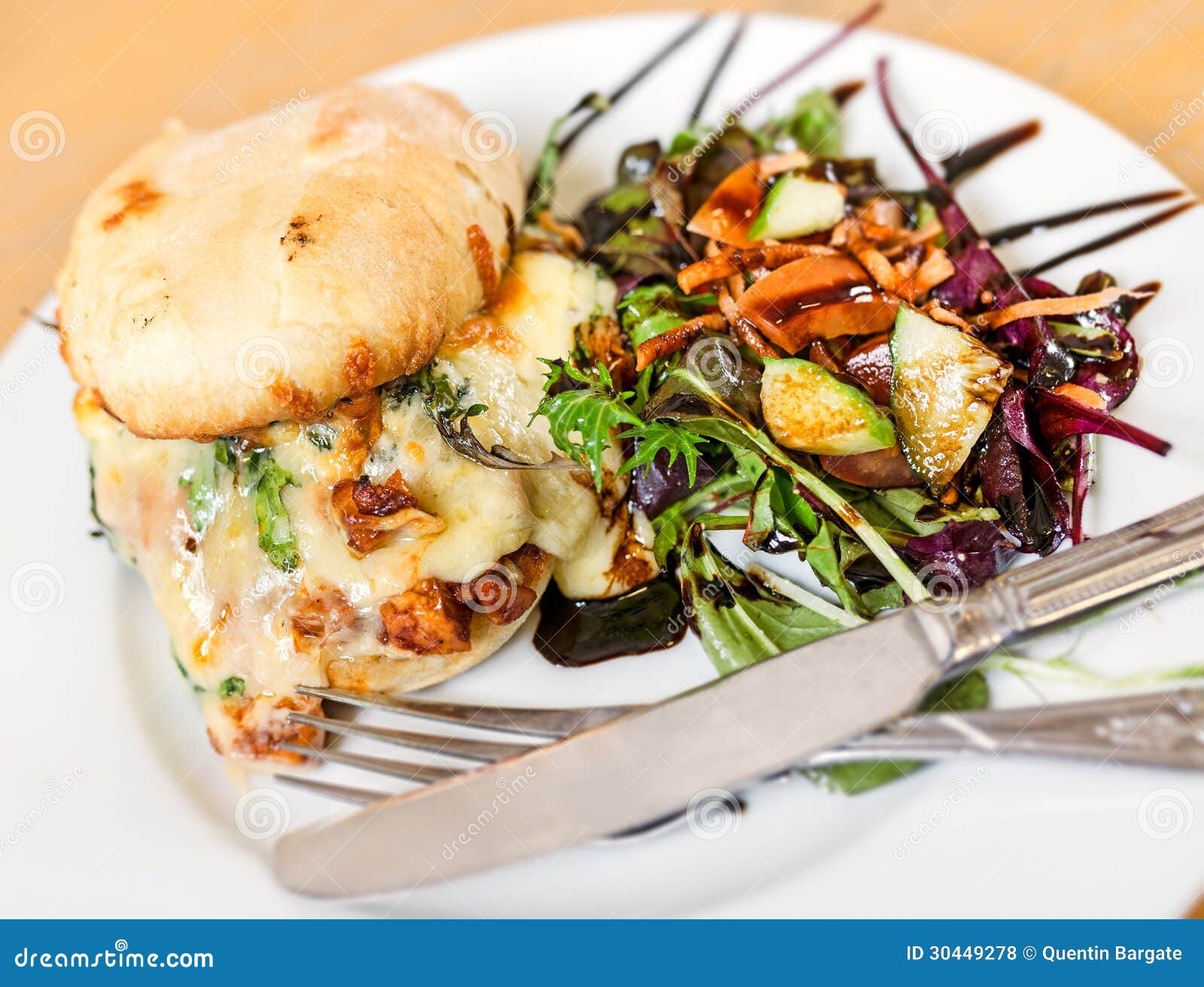 El queso y el pollo tostaron la comida de Ciabatta. El queso y el pollo rellenaron el rollo de Ciabatta con la ensalada y la preparación balsámica