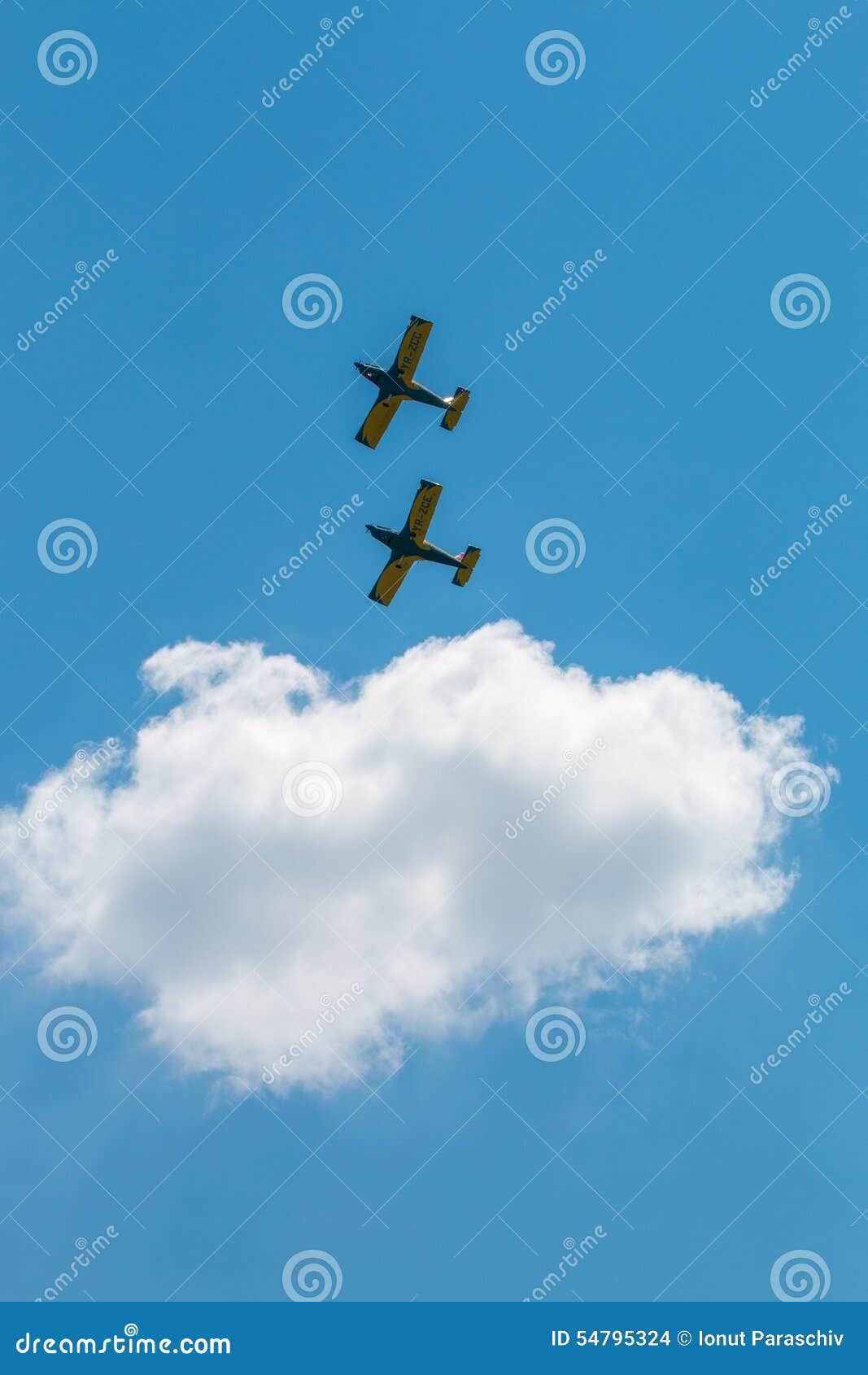 El salón aeronáutico acepilla la formación con las nubes mullidas en fondo. Aeroplanos que vuelan en la formación en cielo azul soleado en el salón aeronáutico en el aeródromo de Clinceni cerca nubes mullidas de Bucarest, Rumania el 30 de mayo de 2015 - en fondo