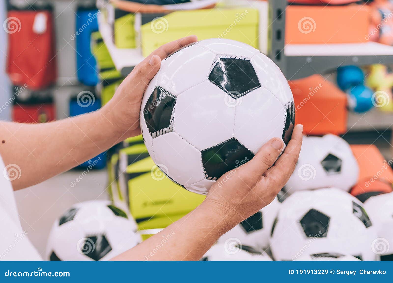 El Tipo Sostiene Una Pelota De Fútbol En Sus Manos En Una Tienda Deportiva  Contra El Fondo De Accesorios Para Deportes Imagen de archivo - Imagen de  deportes, aptitud: 191913229