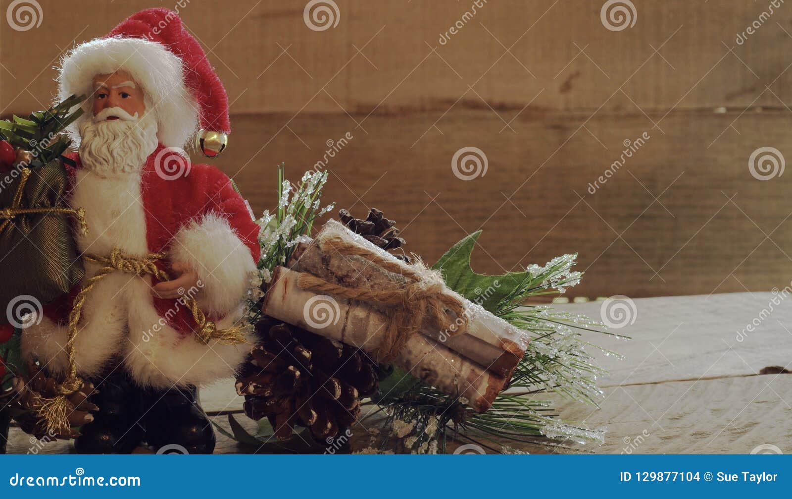 El Verdor Siguiente Permanente De Santa Claus Con Madera Abre Una Sesión Un Paquete En Un Fondo De Madera Foto de archivo - Imagen de fondo, claus: 129877104