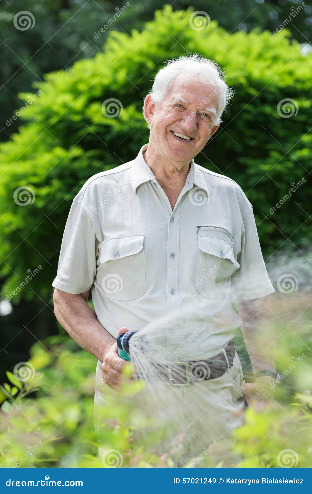 elder gardener with hosepipe