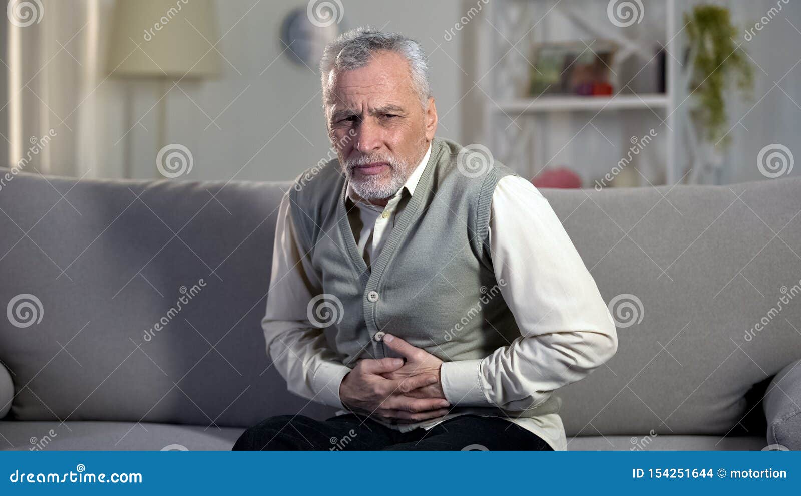 elder male suffering stomach ache, sharp cramps in upper abdomen, indigestion