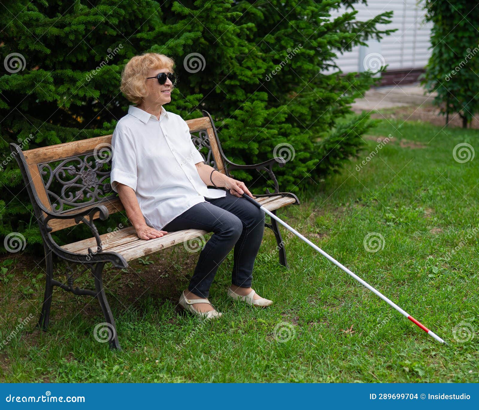 An Elderly Blind Woman Sits on a Bench in the Park. Stock Photo Image