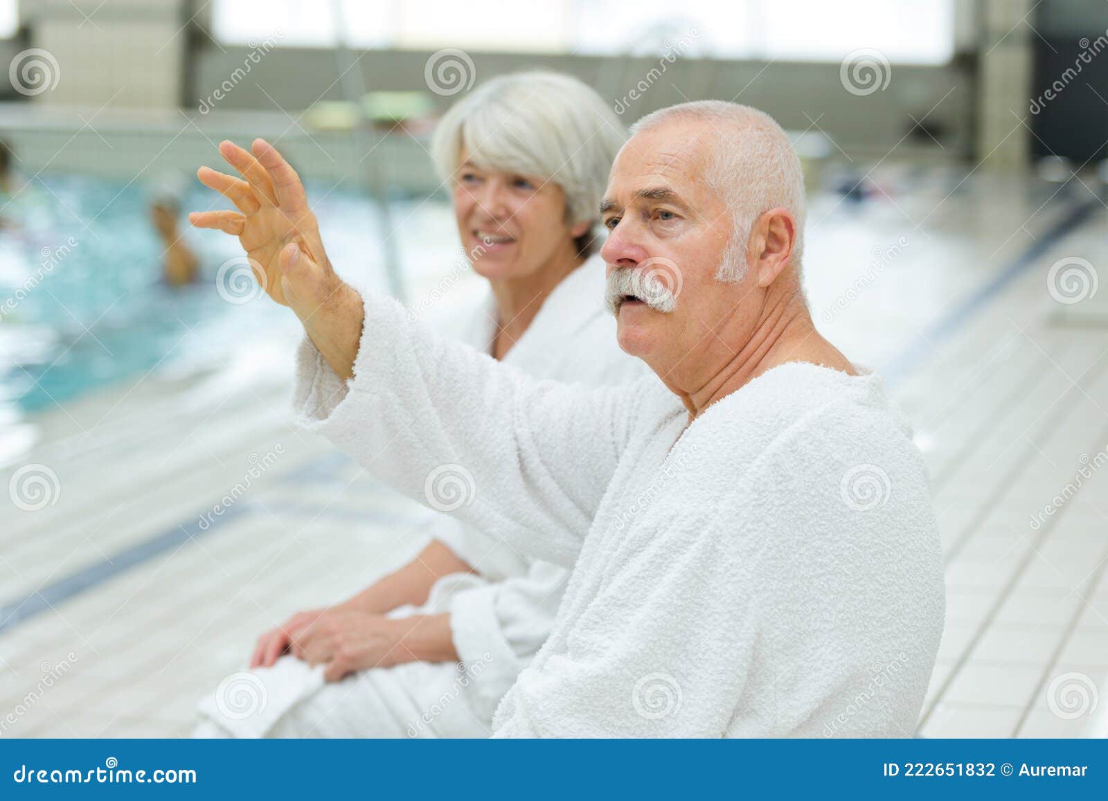 Elderly Couple in Bathrobes Sat Poolside Man Waving Stock Photo Image