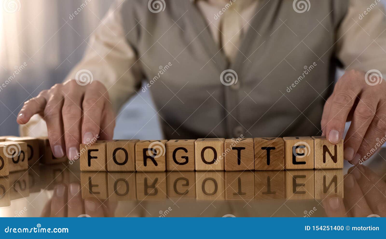 elderly male making word forgotten of wooden cubes on table, dementia disorder