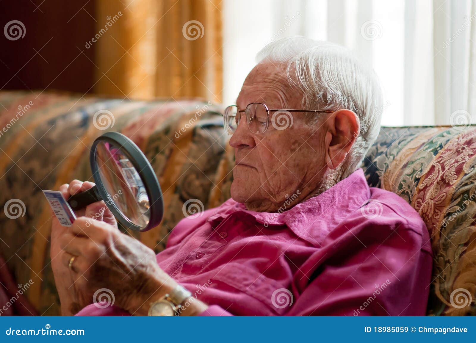 elderly man looking object magnifier 18985059