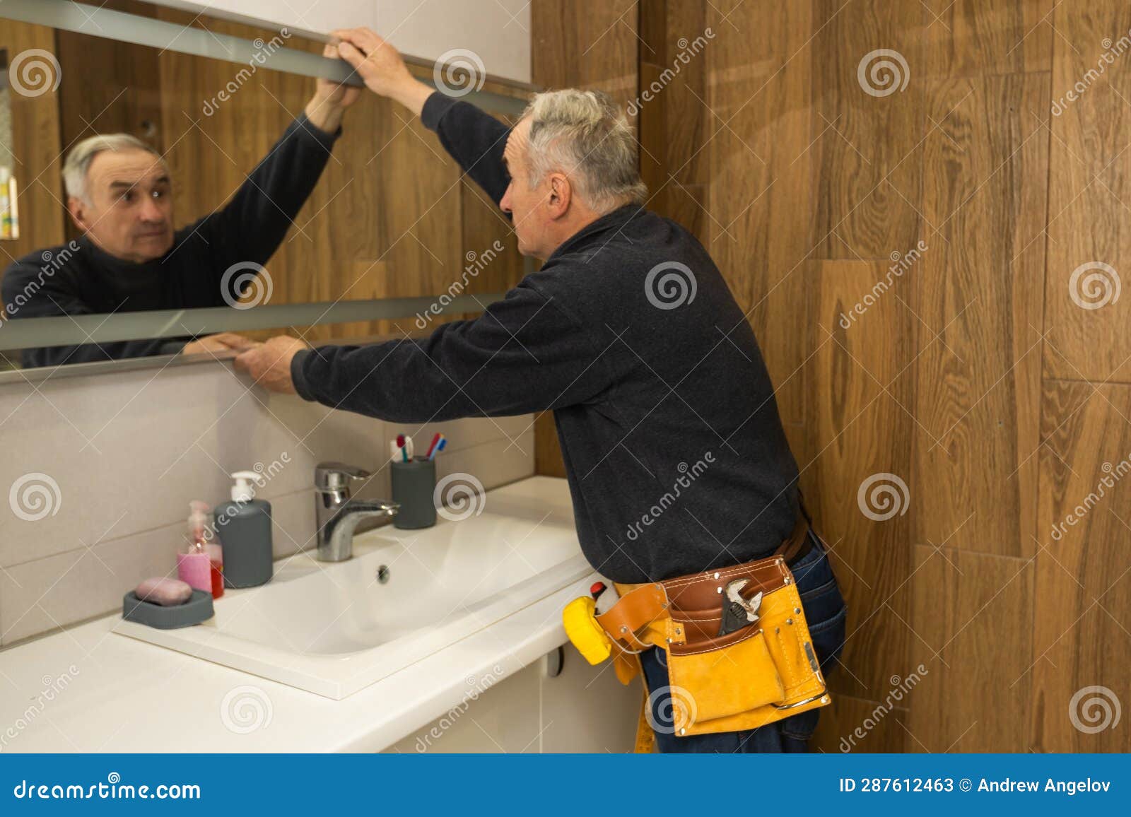 An Elderly Man Repairs a Bathroom Mirror. Stock Image Image of mirror