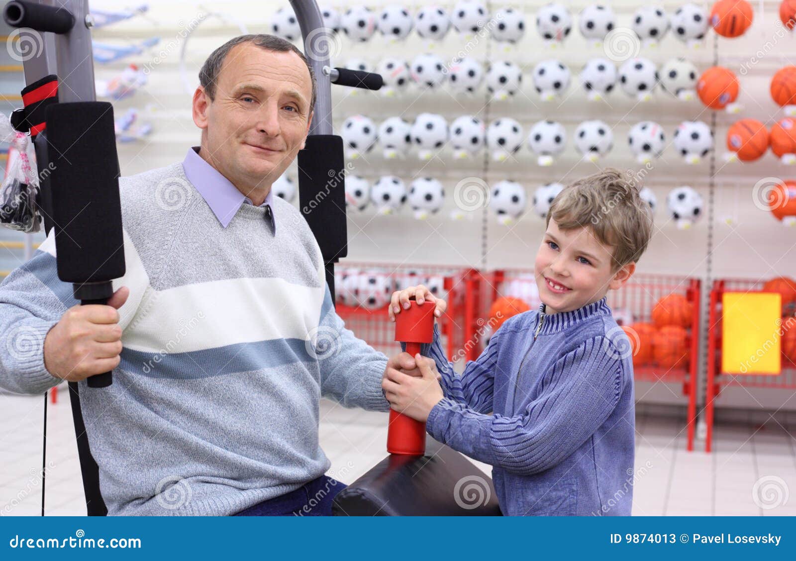 elderly man in shop on sports exerciser and boy
