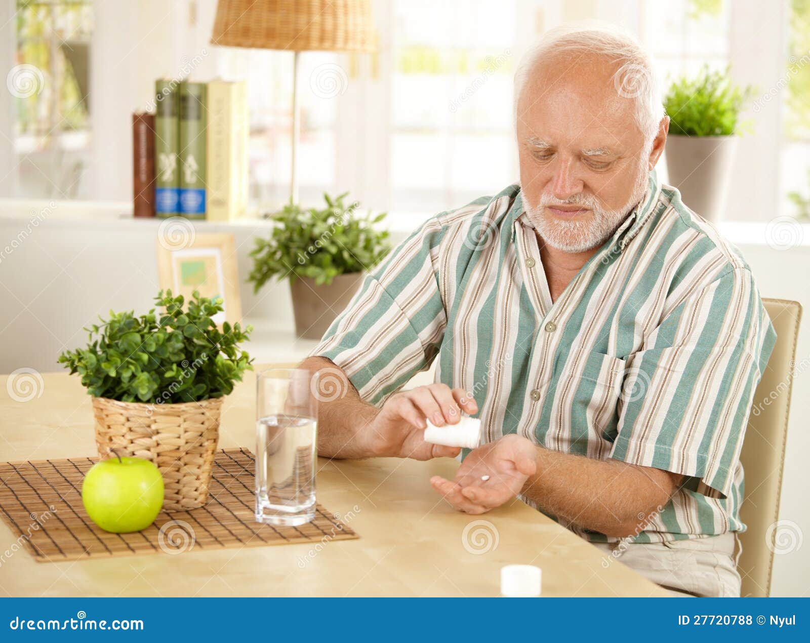 elderly man taking pill at home