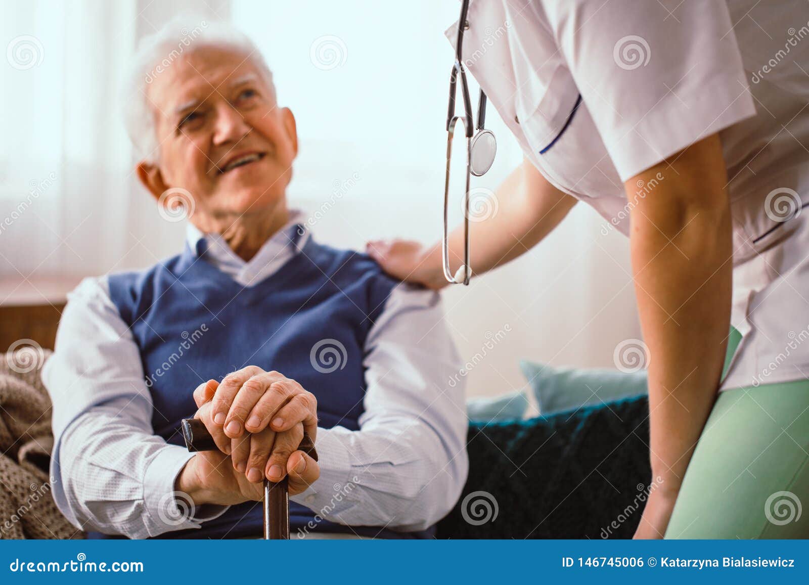 elderly man with stick being comforted by doctor in nursing home