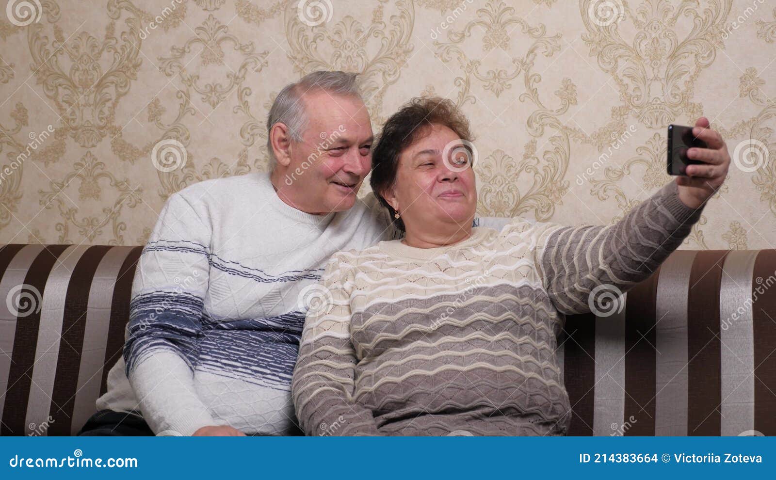 An Elderly, Mature Married Couple Shoot Videos and Photos on a Modern Smartphone