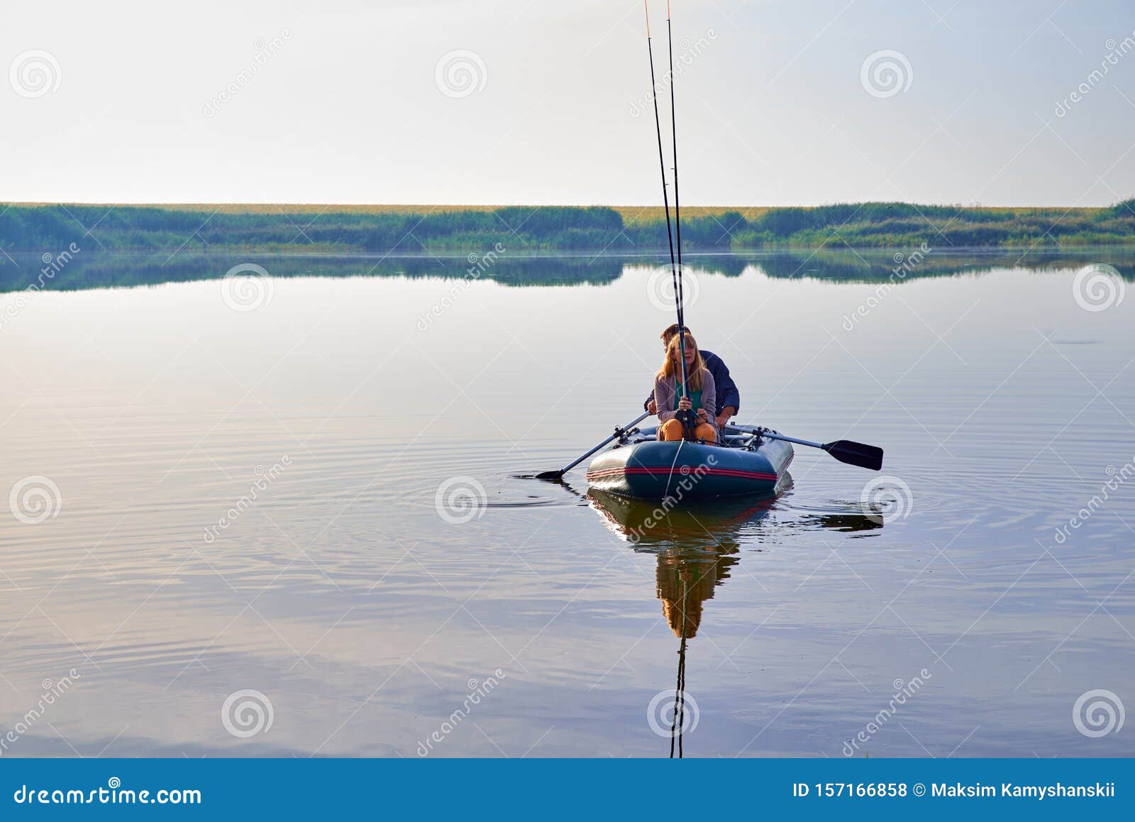 An Elderly People Fishing in Boat Around Forest Stock Photo