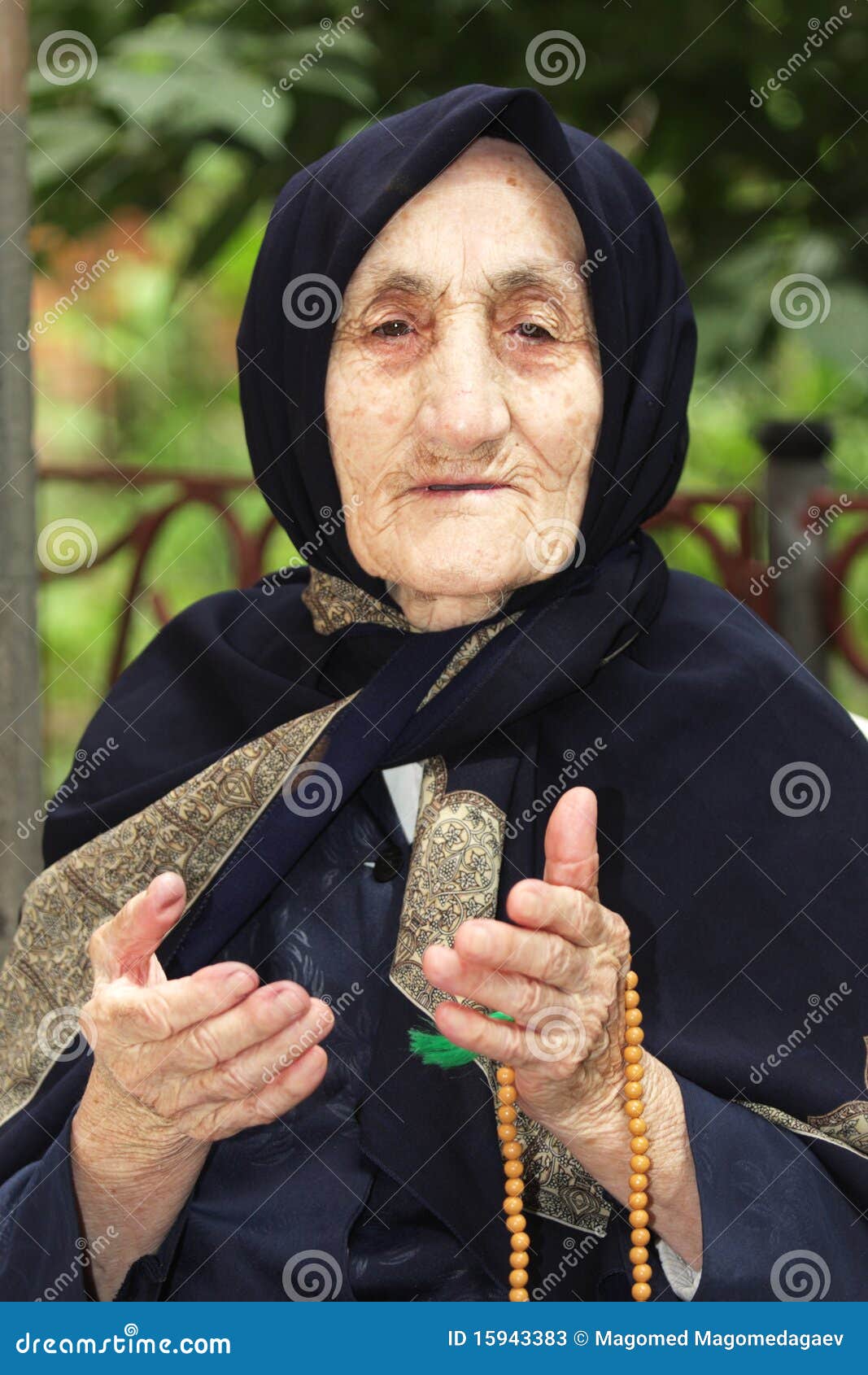 elderly woman with beads gesticulating
