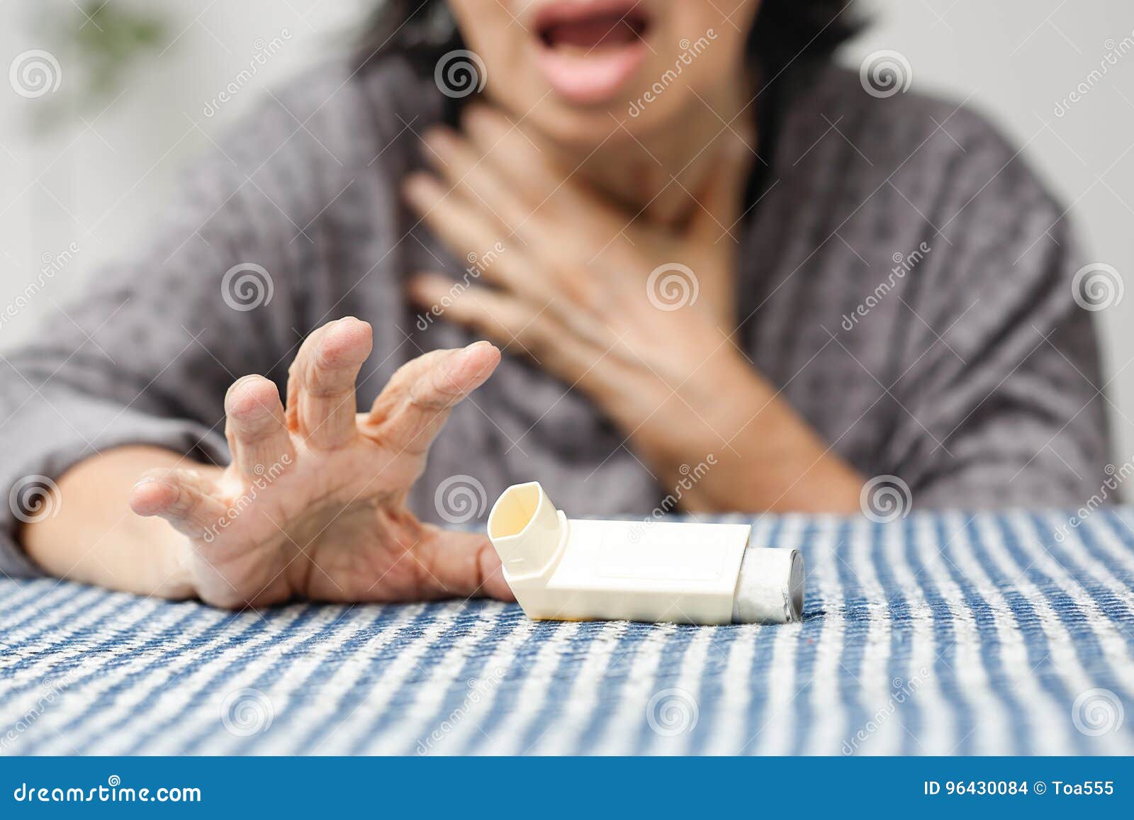 elderly woman choking and holding an asthma spray