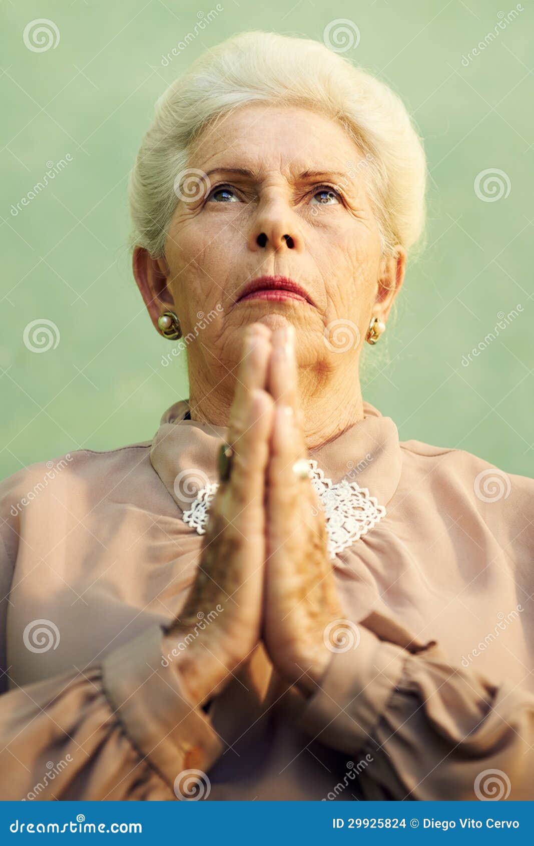 portrait of serious old caucasian woman praying god
