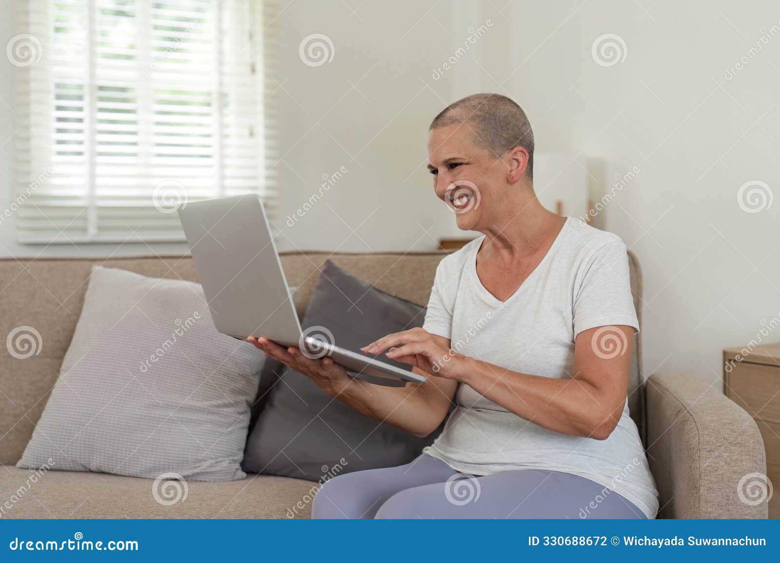 elderly woman relaxing on couch and exploring social media on laptop in cozy home environment