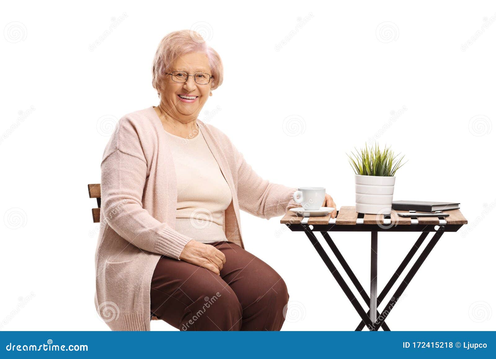Elderly Woman Sitting at a Table with a Cup of Coffee Stock Photo