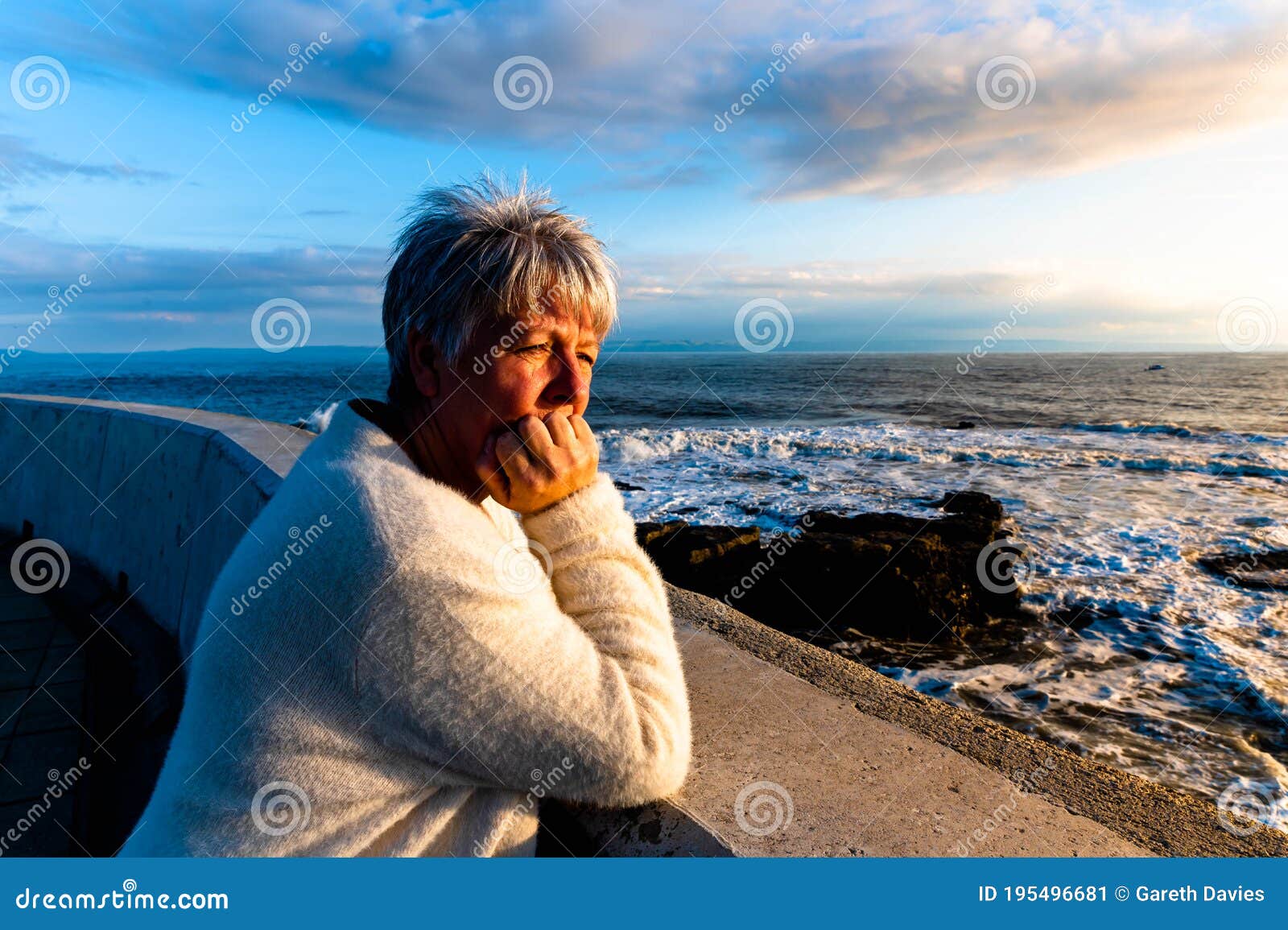 elderly women overlooking ocean sunset at porthcawl.