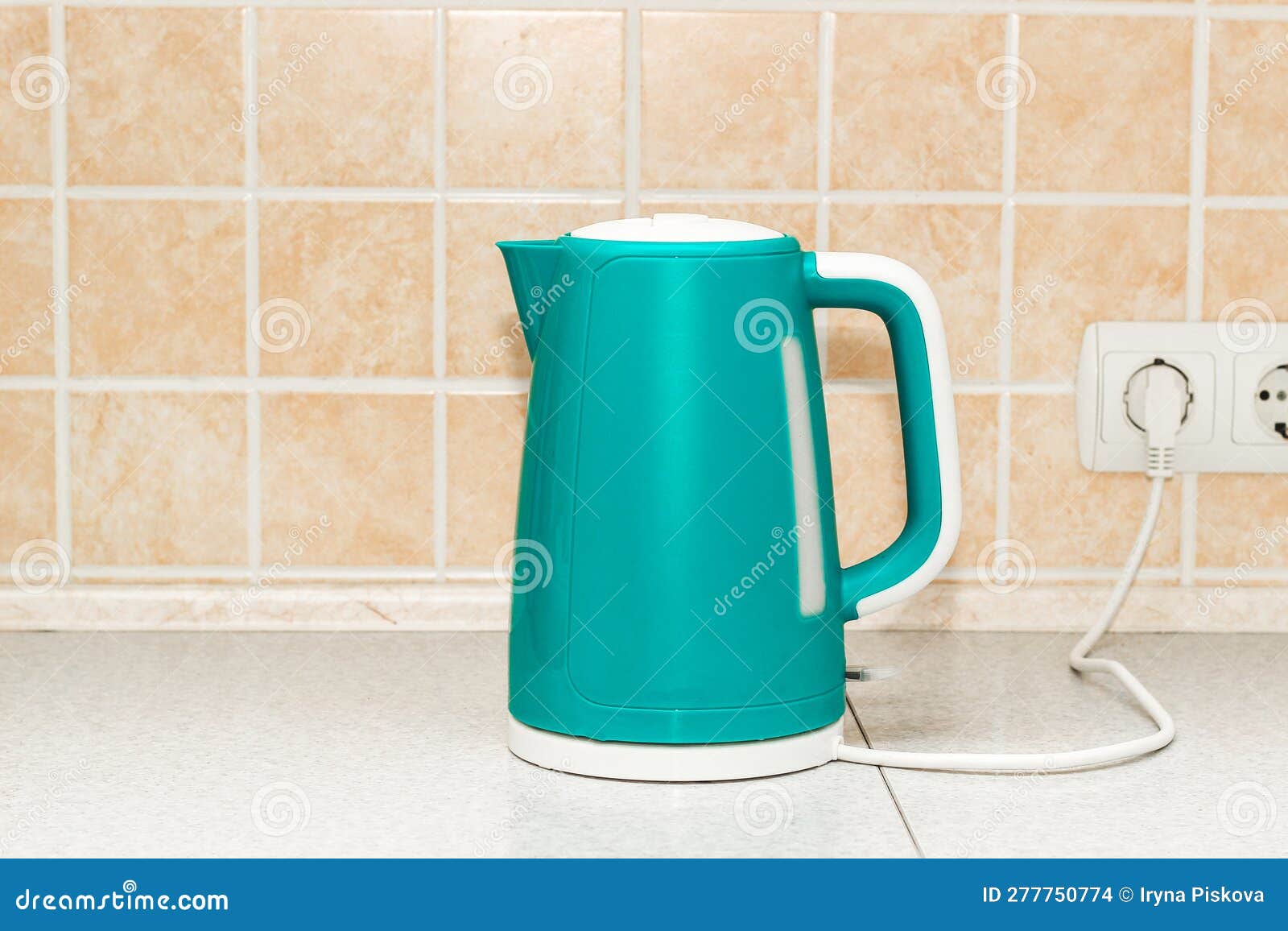 An Electric Bright Kettle Heats Water in the Kitchen Stock Photo